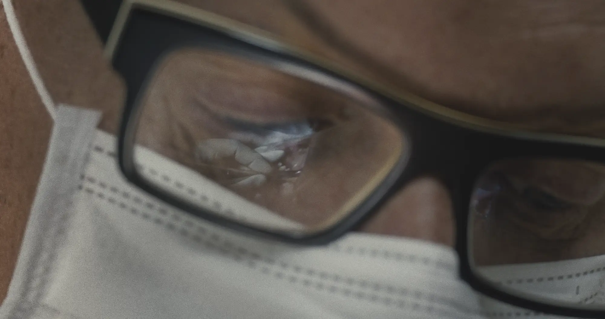 Spiegelung eines Mundinnenraums in der Brille eines Zahnarzts
